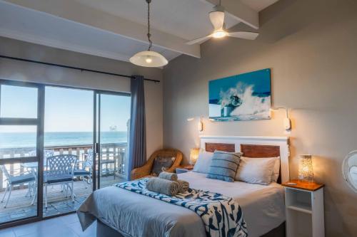 a bedroom with a bed with a view of the ocean at Mitford-on-Sea in Morganʼs Bay