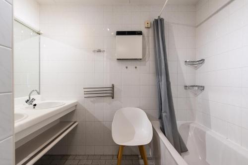 a white bathroom with a white toilet and a sink at Vleijenhof Type C in Buren