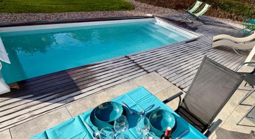 a swimming pool with a table and a pair of sunglasses at Ma Bonne Etoile in Anould