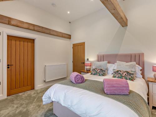 a bedroom with a large white bed with purple pillows at 2 Bed in Carlisle oc-96302 in Scaleby