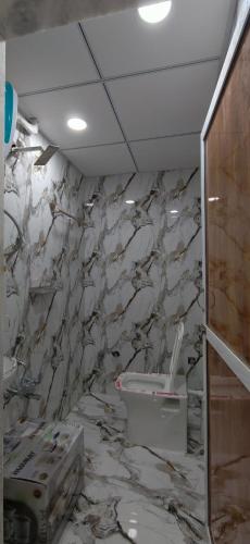 a bathroom with a marble wall with a toilet at Hotel Heritage Prime Junagadh in Junagadh