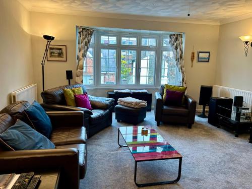 a living room with couches and a coffee table at Bayfields house by the Sea, parking, garden, central location in Portsmouth