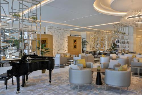 a grand piano in a lobby with chairs and tables at Hilton Dubai Palm Jumeirah in Dubai