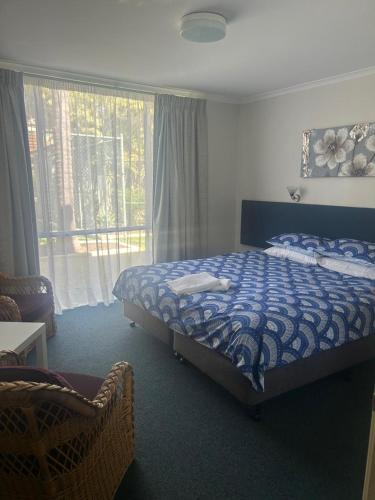 a bedroom with a bed and a large window at Manduhra Motel Resort in Mandurah