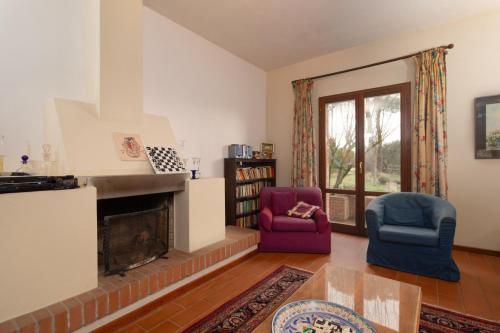 a living room with two chairs and a fireplace at Valdichiana Panorama Villa - Private Pool in Marciano