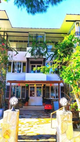a building with a red car parked in front of it at Haluk Otel in Milas