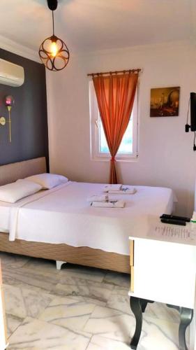 a bedroom with a bed with a sink and a window at Haluk Otel in Milas