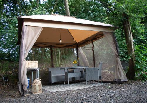 a tent with a table and chairs under it at Tiny bubble Tree Tent in private woodland in Kent