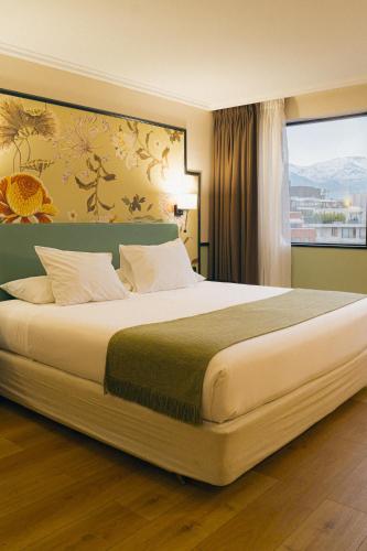 a large bed in a hotel room with a window at Hotel Director Vitacura in Santiago
