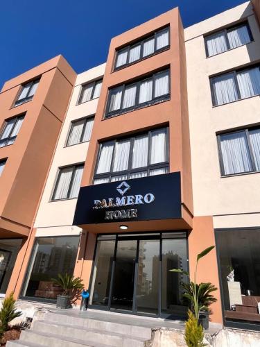 a building with a sign for a hotel at Palmero Butik Otel in Çiftlikköy