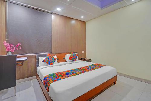 a bedroom with a large bed and a chalk board at FabHotel HM Inn in Lucknow