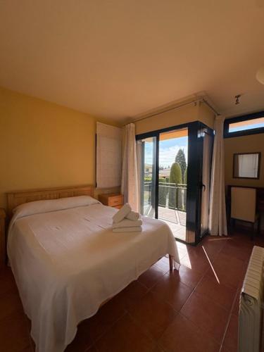 a bedroom with a white bed and a large window at Villa Torremirona Resort Palmeras in Navata