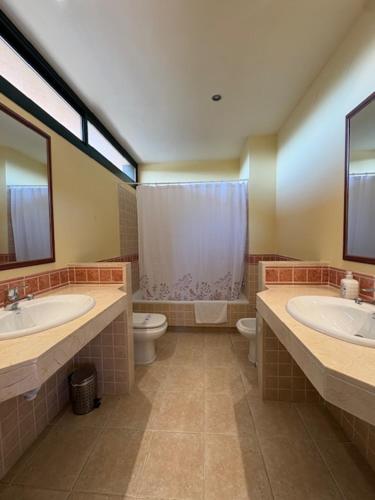a bathroom with two sinks and a toilet at Villa Torremirona Resort Palmeras in Navata