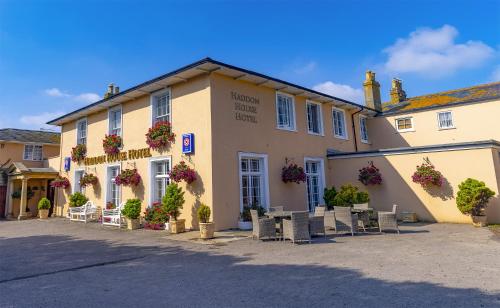 a building with tables and chairs in front of it at Haddon House Hotel in Bridport