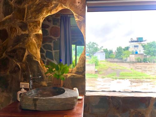 a stone bathroom with a stone sink and a window at Rocky Mountain Ecology in Xuân Sơn