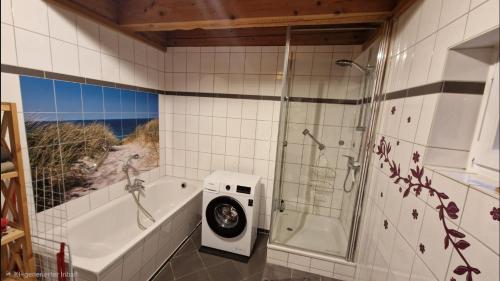 a bathroom with a shower and a tub and a washing machine at Staar in Hohenfelde