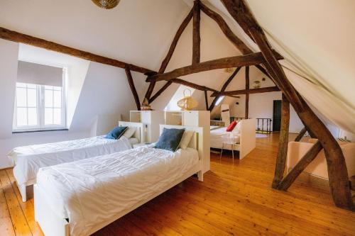 ein Schlafzimmer mit zwei Betten im Dachgeschoss in der Unterkunft Le Petit Hômage in Lanaken