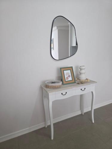 a white dressing table with a mirror on a wall at Pacific blue cómodo y familiar in La Serena