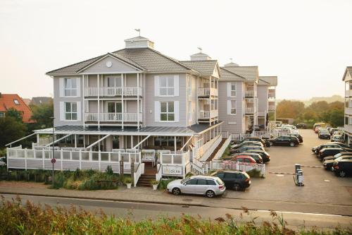 a large building with cars parked in a parking lot at Beach Motel St. Peter-Ording in Böhl