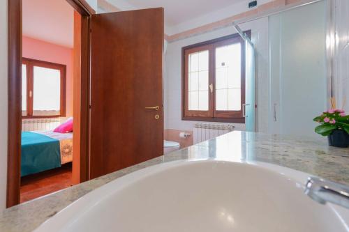 a bathroom with a tub and a bedroom with a bed at B&B Gassa d'Amante in Capoterra