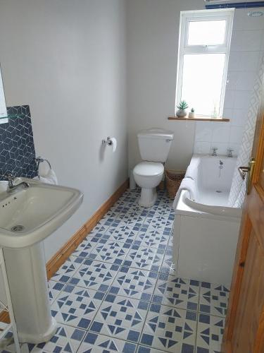 a bathroom with a toilet and a tub and a sink at Cootehall in Boyle
