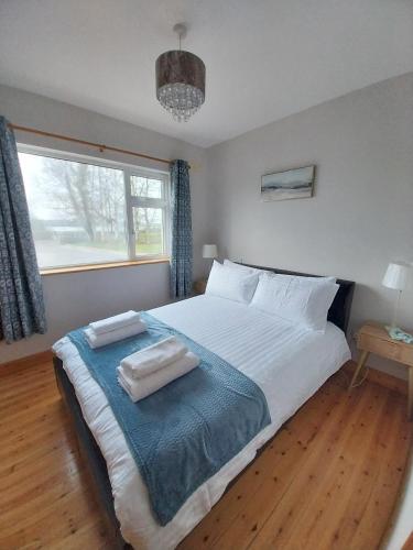 a bedroom with a large bed with two pillows on it at Cootehall in Boyle