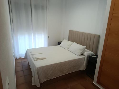 a bed with white sheets and pillows in a bedroom at Spa Valley II experiences Penthouse con Piscina climatizada y Yacuzzi in Villanueva de Río Segura