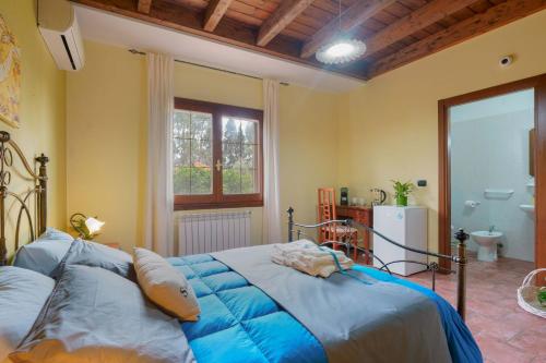 a bedroom with a large bed and a bathroom at B&B Gassa d'Amante in Capoterra