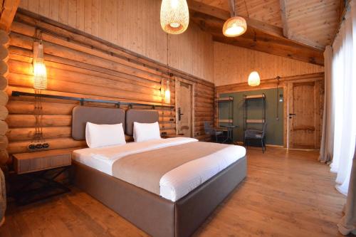 a bedroom with a large bed in a room with wooden walls at Wooden villa with superpool and sauna, 30 min from Yerevan in Tsakhkashen