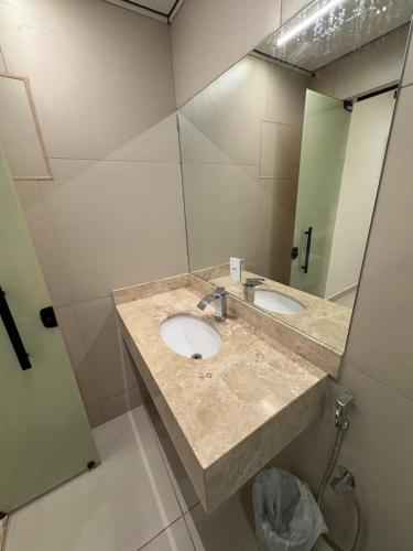 a bathroom with two sinks and a large mirror at Suítes Pousada Canaã in Araxá