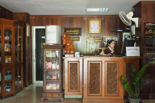 a woman standing at the counter of a store at ภูตะวัน กาญจน์ รีสอร์ท Phutawan Kan Resort in Kanchanaburi City