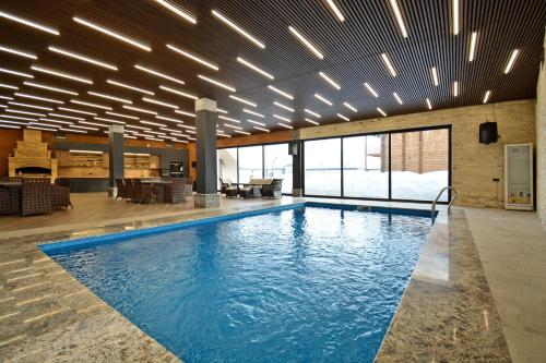 a swimming pool in a large room with a large ceiling at Wooden villa with superpool and sauna, 30 min from Yerevan in Tsakhkashen