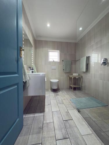 a bathroom with a tub and a toilet and a sink at BlueSky Arniston Boutique Guesthouse in Arniston