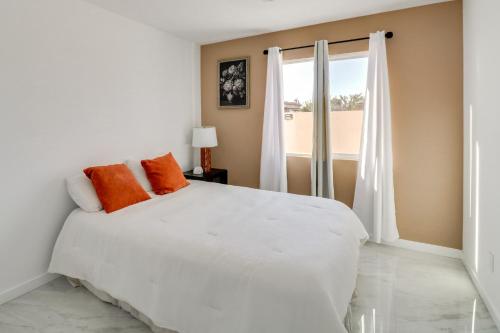 a white bedroom with a large bed and a window at 13 Mi to Universal Studios: Renovated Cottage! in Los Angeles
