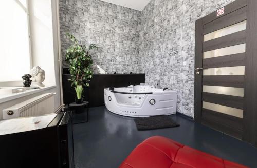 a living room with a door and a room with a plant at Wellnes apartmán Leqwell in Uherský Brod