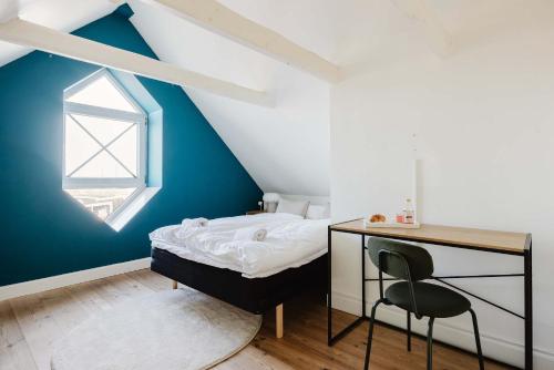 a bedroom with a bed and a desk and a window at Odense Doublex Penthouse in Odense