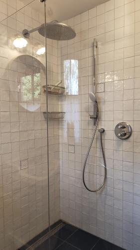 a shower with a glass door in a bathroom at Holiday home bos en heide in Otterlo