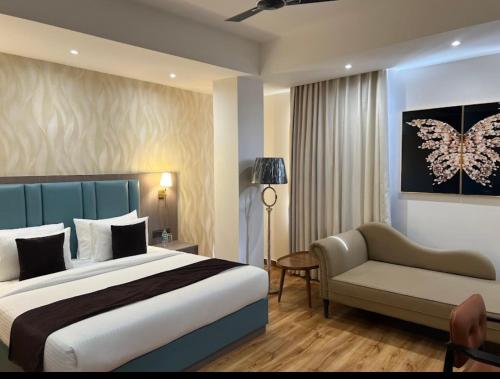 a bedroom with a bed and a couch and a chair at Aair Hotel And Resorts in Karnal