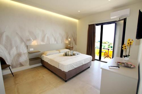 a bedroom with a large bed and a large window at I Settembrini in Capo Vaticano