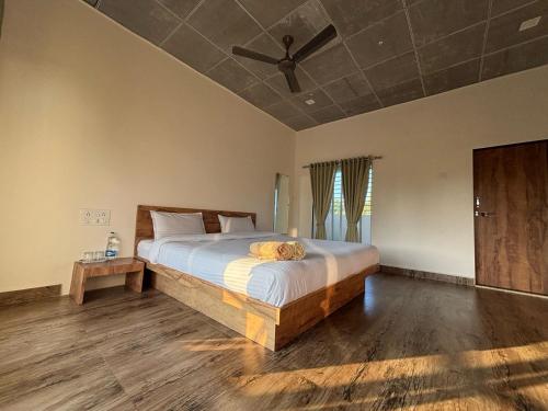 a bedroom with a bed and a ceiling fan at Vanray Farm And Resort in Talala