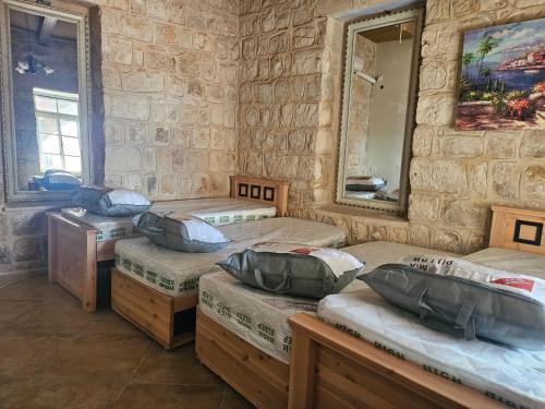 a room with three beds and a mirror at בית האומן in Safed