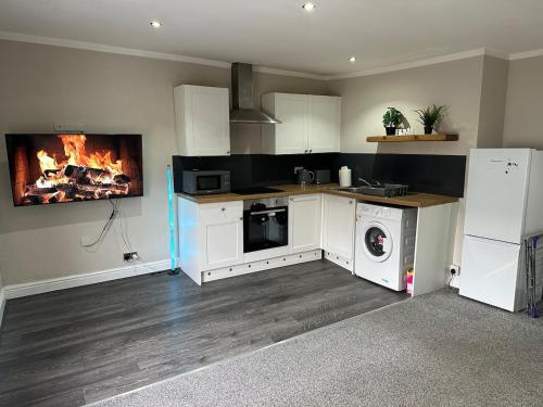 a kitchen with a stove and a fire in the wall at Modern 2 Bed Apartment, Sleeps 4 in Bolton