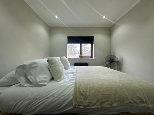 a bedroom with a large white bed with a window at Modern 2 Bed Apartment, Sleeps 4 in Bolton