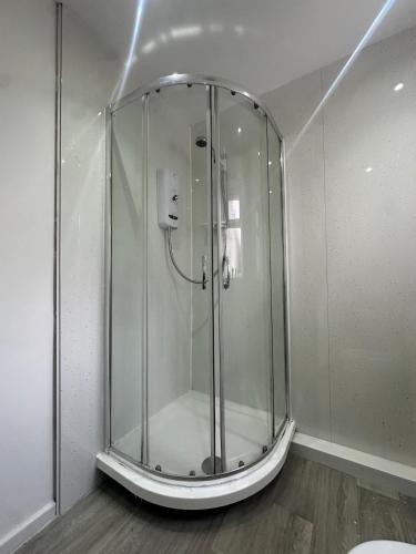 a glass shower in a room with a wooden floor at Modern 2 Bed Apartment, Sleeps 4 in Bolton