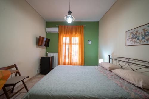 a bedroom with a bed and a window with an orange curtain at Delphian Colors - Orange Edition by Filos Inc in Delphi