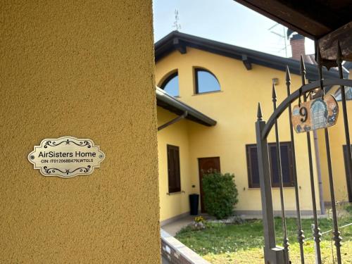 a sign on the side of a house with a fence at AirSisters Home in Ferno