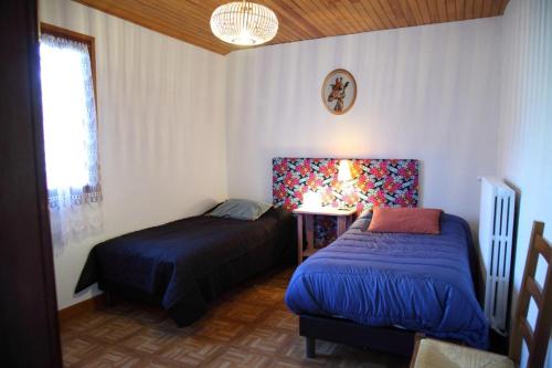 a bedroom with two beds and a window at Gîte avec jardin pour 6 pers près de Salers Nature & Puy Mary in Le Vigean
