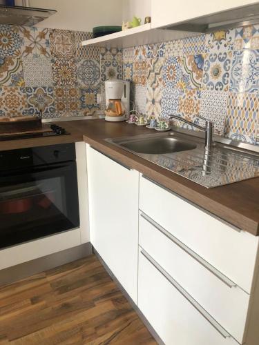 a kitchen with white cabinets and a sink at Kasakarma in Agira