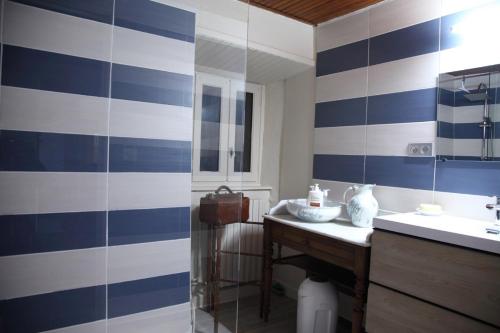 a bathroom with blue and white stripes on the wall at Gîte avec jardin pour 6 pers près de Salers Nature & Puy Mary in Le Vigean