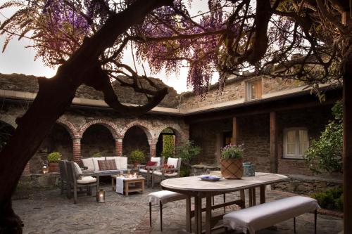 a patio with a table and chairs under a tree at Eremo della Maddalena the oasis of the 5Terre in Monterosso al Mare